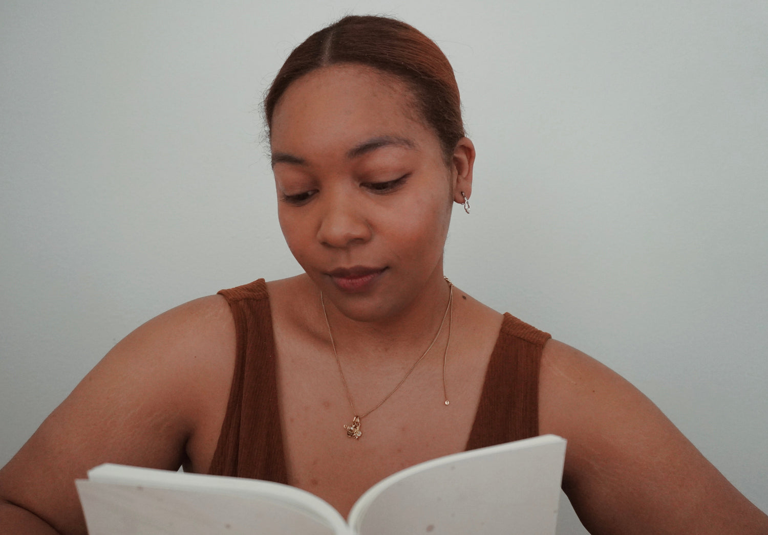 Woman reading a book against a plain background